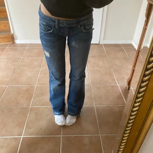 Lågmidjade jeans  - Lågmidjade jeans med slitningar och som ett inbyggt skärp i jeans. Säljer då de inte kommer till användning. De är uppsprättade där nere men det ser bra ut då det är håliga jeans. Jag är 170 cm och de sitter bra  Köparen står för frakt 