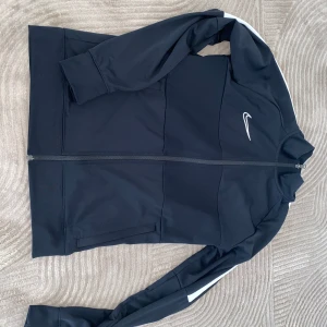 Nike tränings tröja man stl M - Säljer en nike träningströja i storlek M från man avdelning. Det är gott som ny. Inget slitage.  Färgen e svart och inte marinblå. 