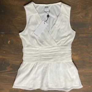 Vera Moda Topp  - Tröjan är för liten så kan inte visa hur den sitter på. Storlek S, nypris 250kr. Köptes för 50% off. Prislapp kvar men finns små mörka fläckar, knappt synliga. Finns även slitningar på ena axeln, syns på bild 2. Diskret dragkedja på ena sidan. 
