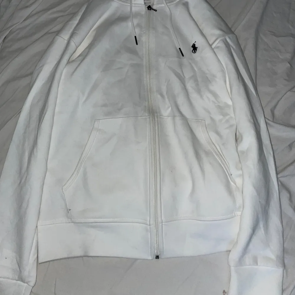 Hej säljer nu denna polo hoodie i färgen vit. Använd ett fåtal gånger, inga skador eller liknande utöver att dragkjedjan är lite trög ibland där av det billiga priset.. Hoodies.