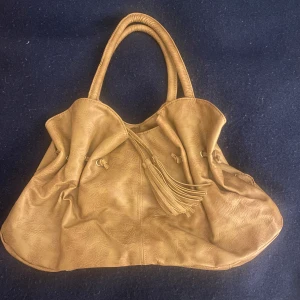 Beige unik y2k väska - Säljer denna superfina unika beigea väska. Den har en dragkedja på insidan och en fin fransdetalj på framsidan som kan tas av om man vill. Skriv för mer info💗