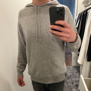 Davida Cashmere Hoodie - Grymt tillfälle till bra pris! Säljer min väldigt få gånger använda Hoodie i 100% Cashmere från Davida i storlek medium som inte säljs längre. Skick 9/10. Den är ljusgrå! Nypris 2499kr.