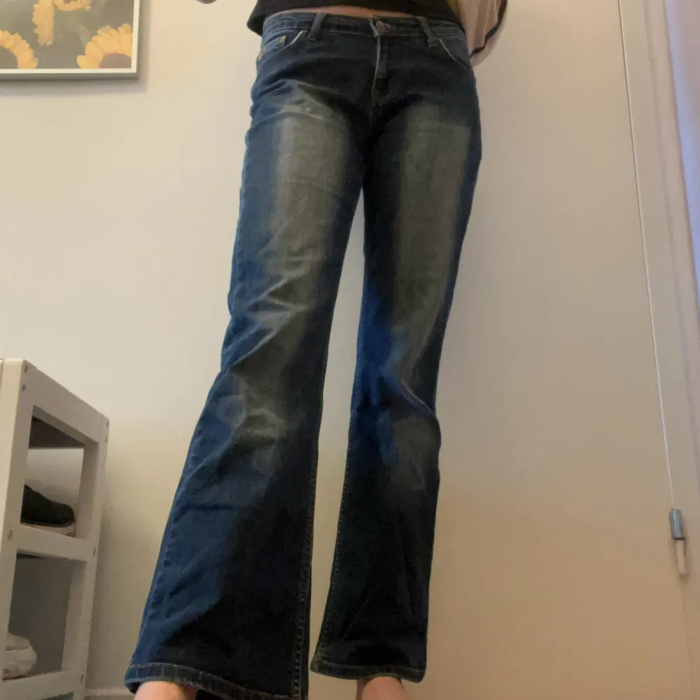 Mörkblå jeans med låg midja och utsvängda ben från Blend! Fint skick. Jag på bilden är ca 175cm. OBS! Ungefärliga mått: midja ca 80cm, innerben ca 80cm, grenhöjd ca 20cm. 👼. Jeans & Byxor.