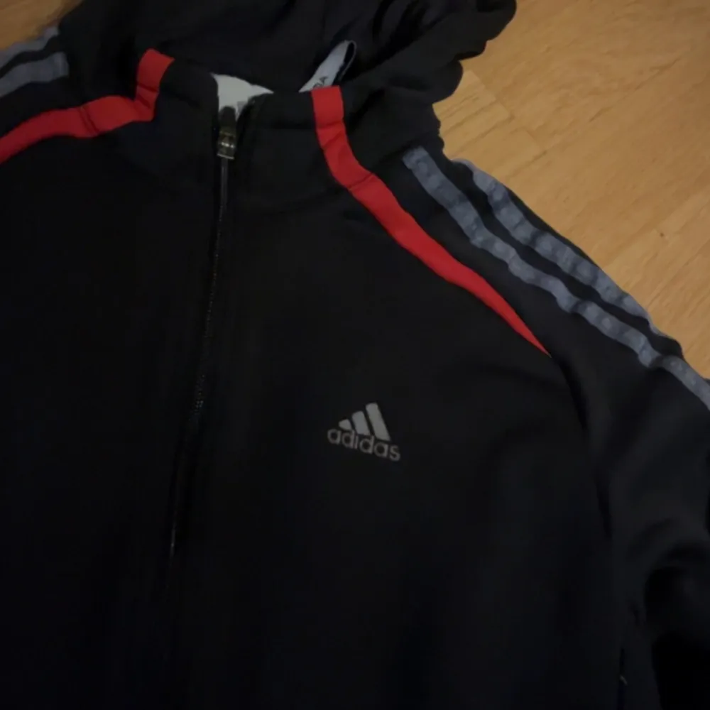 Svart adidas zipup men grå tänder o röda detaljer, en liten fläck på framsida men syns knappt.. Tröjor & Koftor.