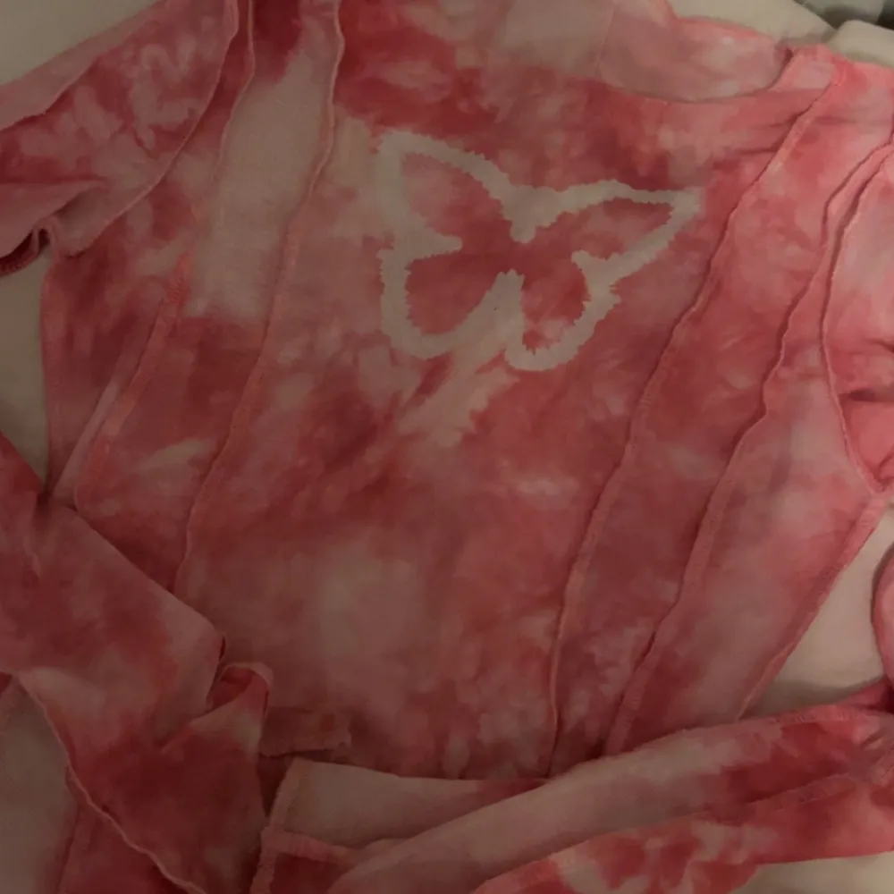 Långärmad rosa fjäril tröja som även är genomskinlig, denna tröja passar med en kortärmad vit tröja under (enligt mig). Säljer denna då den inte används längre. Köpt i en butik i London (England). . Tröjor & Koftor.