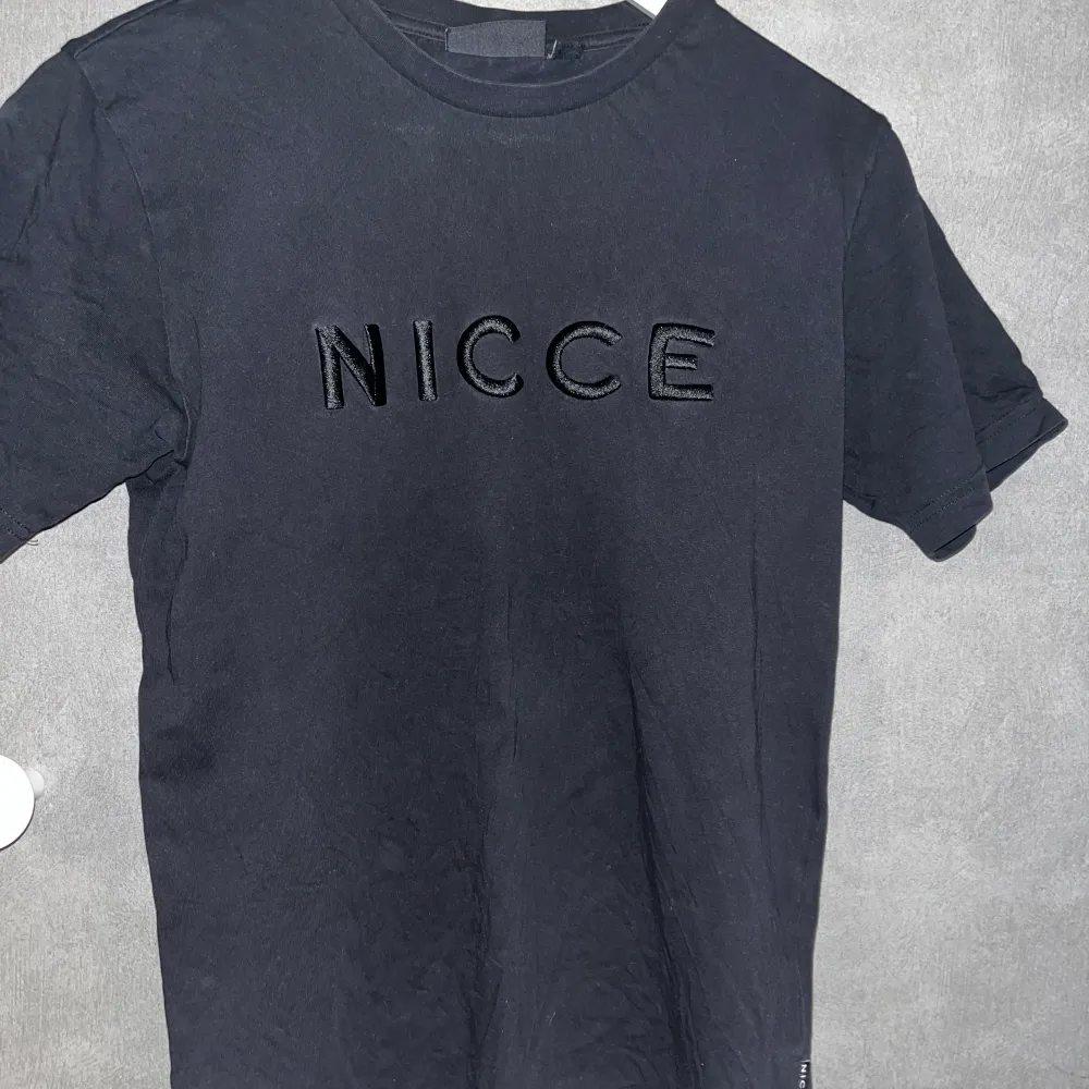 Svart Nicce T-shirt med fett tryck. Köpt för runt 400kr. Säljer pågrund av att jag har växt ur den. T-shirts.