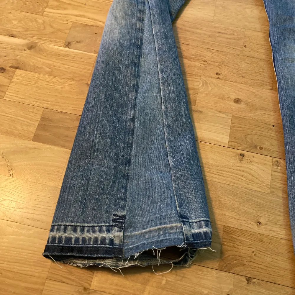 Ljusblå vintage bootcut/flare jeans i helt okej skick. Väldigt slitna längst ner (hör av dig om du vill ha bild), knappen sitter löst och hål i fickorna. Skulle säga att dem är som storlek 31.. Jeans & Byxor.
