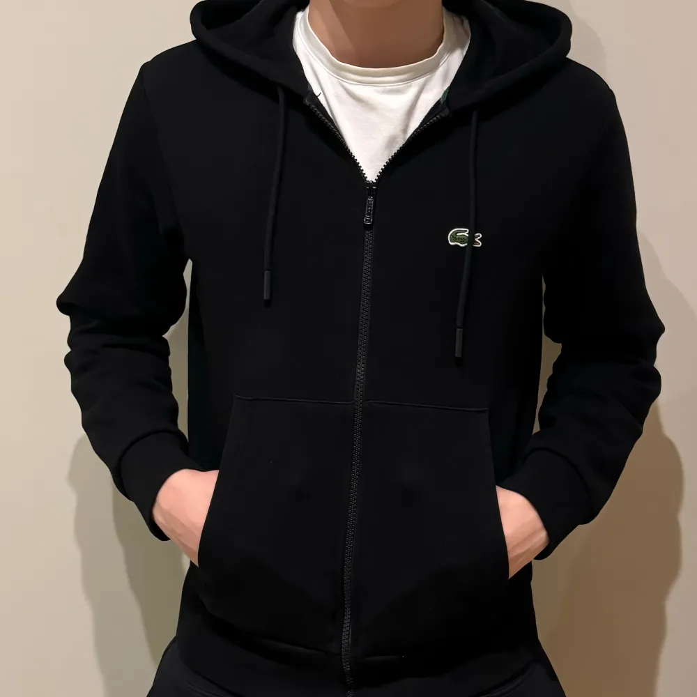 Lacoste Hoodie med dragkedja i stl S (FR 3)  Den är i bra skick (8/10) och köpt i USA Modellen är 180 cm Ordinarie pris är 1400kr Pris kan diskuteras! . Hoodies.