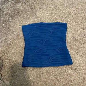 Blå tubtopp - Blå tubtopp i vågigt mönster storlek 38 aldrig använd då den sagt för tajt runt bysten men orkade aldrig returnera skulle rekomedera till någon som har lite mindre bröst i storlek 38 eventuellt någon med större bröst fast mindre i storleken (Gratis)