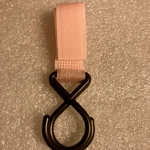 *NY*Ljusrosa krok för barnvagn  - Dubbelkrok för barnvagn i hårdplast med kardborreband.