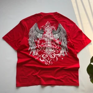 T-Shirt Kors Affliction Draingang Opium - Storlek L, Längd: 72 Bredd: 57 En snygg boxig t-shirt i Affliction stil, väldigt bra material, perfekt för sommaren. Högkvalitativt tryck, perfekt skick utan några defekter