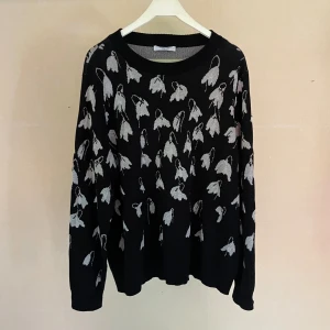 Mayfair by Peter Hahn- Svart stickad tröja - Mayfair By Peter Hahn- En svart stickad tröja från med ett mönster av vad som ser ut som vita blommor. Tygets sammansättning plus att det är oanvänt gör det väldigt mjukt och mysigt. - Material: 87% bomull, 13% viskos. - Storlek: FR48~ Medium