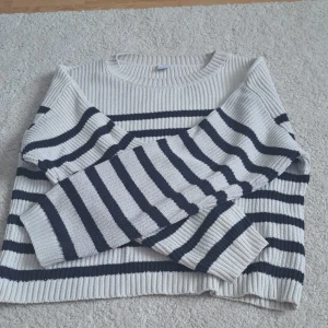 Stickad tröja  - En randig stickad tröja som är medel använd men inga defekter