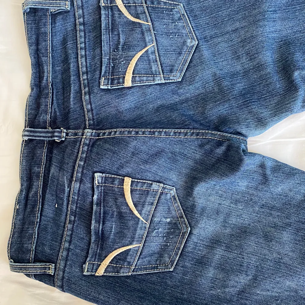 Jättesnygga lowrise mörkblå jeans med vita sömmar och detaljer på fickorna. Köpta second hand men aldrig använda. Straight/bootcut . Jeans & Byxor.