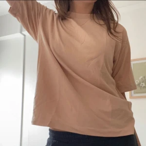 Lyxig t-shirt  - T-shirt i persika-färg i bra kvalitet. Nästan aldrig använd. Fina detaljer vid halsen och på ryggen. 