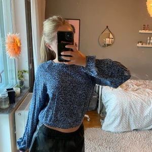 Blommig blus  - Blåblommig blus med puff-ärmar och öppning samt rosett i ryggen, endast använd 1 gång! 💙Stl L barnstorlek från Mango (Xs/S) 