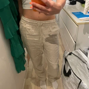 Linnebyxor  - Beige linnebyxor med lågmidja. 