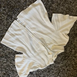 Vit blus med knappar  - Kortärmad blus med knappar och vida ärm. Använd fåtal gånger. Superfin och enkel, går att klä upp och klä ner. 