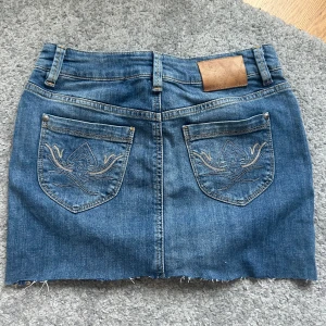 Jeanskjol - Världens finaste Lågmidjade jeanskjol. Storlek 34/36. Midjemått: 35 cm  Längd: 32. 