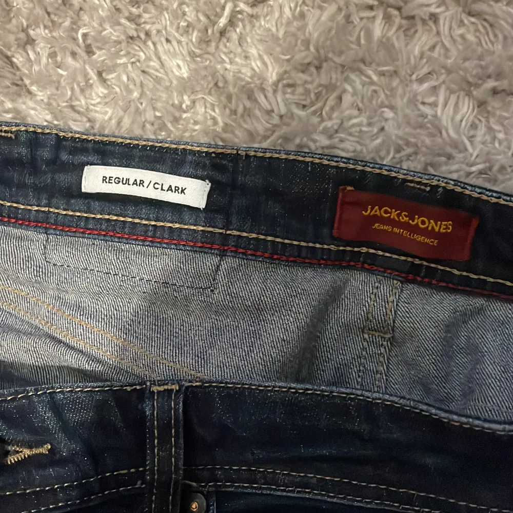 Mörkblå jeans från Jack and Jones i modellen regular/clark. Storlek 28/32. Nypris runt 600 och i bra skick (7/10 då loggan där bak är av på mitten).Hör av er vid prisförhandling, fler bilder, mått eller  andra tankar så kommer svar snabbt💫. Jeans & Byxor.