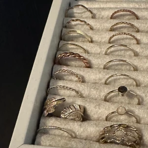 Guld ringar  - 18 stycken guldringar från hm. Färgen är lite otydlig på bilden men de är guldiga 