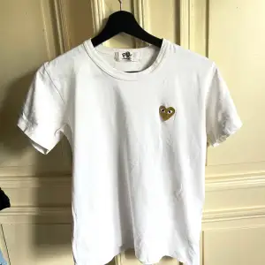 En vit T-shirt ifrån Play Comme des garcons med ett guld hjärta. Har denna i storlek L då jag inte ville ha den som en tajt t shirt.  Är själv i storlek S/M.