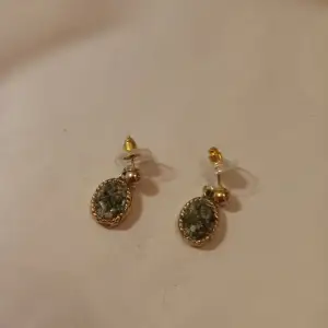 Vintage örhängen med hänge av en medaljong med gröna stenar guldfärgad .