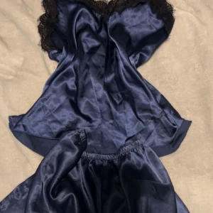 Pygamas sätt - Marinblått siden pygamas sätt med svart späts ser som nytt ut. Lapparna är borta vet inte vars dem är från möjligtvis hunkemöller? Skriv för mer frågor eller bilder😊