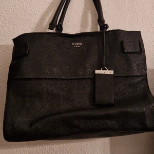 Guess väska - Svart väska från Guess. Får plats med dator osv. Sparsamt använd. Nypris: 1600:-