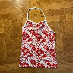 Somrig halterneck - Gullig halterneck med blommönster. Barnstorlek men passar XS. Går att vika ner så det blir en bandeautopp också. 