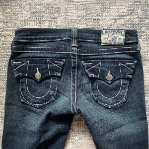 Lågmidjade bootcutjeans True Religion - Så snygga lågmidjade bootcut jeans från True Religion. Modell Billy. Har tyvärr inga bilder hur de sitter på då de är för små för mig💞Jättefint skick Midja: 38 cm Innerbenslängd: 82 cm Bredd nedtill: 18,5 cm