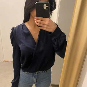 Blus - Marinblå satin blus med lite puffärm detalj från boohoo, säljer eftersom den har inte kommit till använding på grund av att den är för stor. 