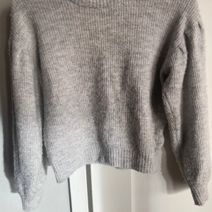Grå stickad tröja med puffärm tjej 146/152 - Grå stickad tröja med puffärm som snygg detalj. Skönt material. Storlek 146/152 från H&M. 