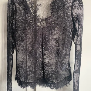 Svart spetstopp strlk 36 - Svart festlig genomskinlig spetstopp. V-ringad. Storlek 36. Från H&M. Väldigt fint skick. Rök- & djurfritt hem. 