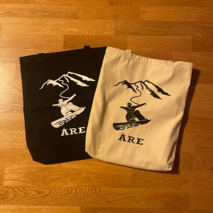 Åre Tygpåsar - Säljer en skitsnygg vattentät Åre tygpåse (den svarta) då den inte används så mycket längre. Den har 2 små fickor i sig och den har hållt jättbra även fast den använts på daglig bas.  Köparen står för frakt eller så hämtas den i Östersund