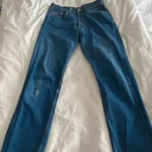 Vintage mörkblå Levis jeans 501. Slitning på knät. Står ingen storlek men måtten är: Midjan 30cm Innerben 75cm  Ytterbenlängd 103cm