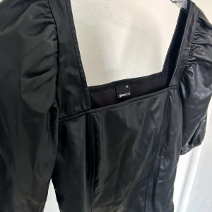 Snygg skinn topp - Den perfekta fest toppen! Svart skinn topp, aldrig använd. Den är lite skrynklig på bilden då den har legat ihopvikt i garderoben. Sitter väldigt smickrande på!