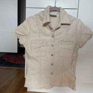Söt skjorta som funkar att ha både öppen och stängd. Har knappar längst frma och materialet liknar linne.