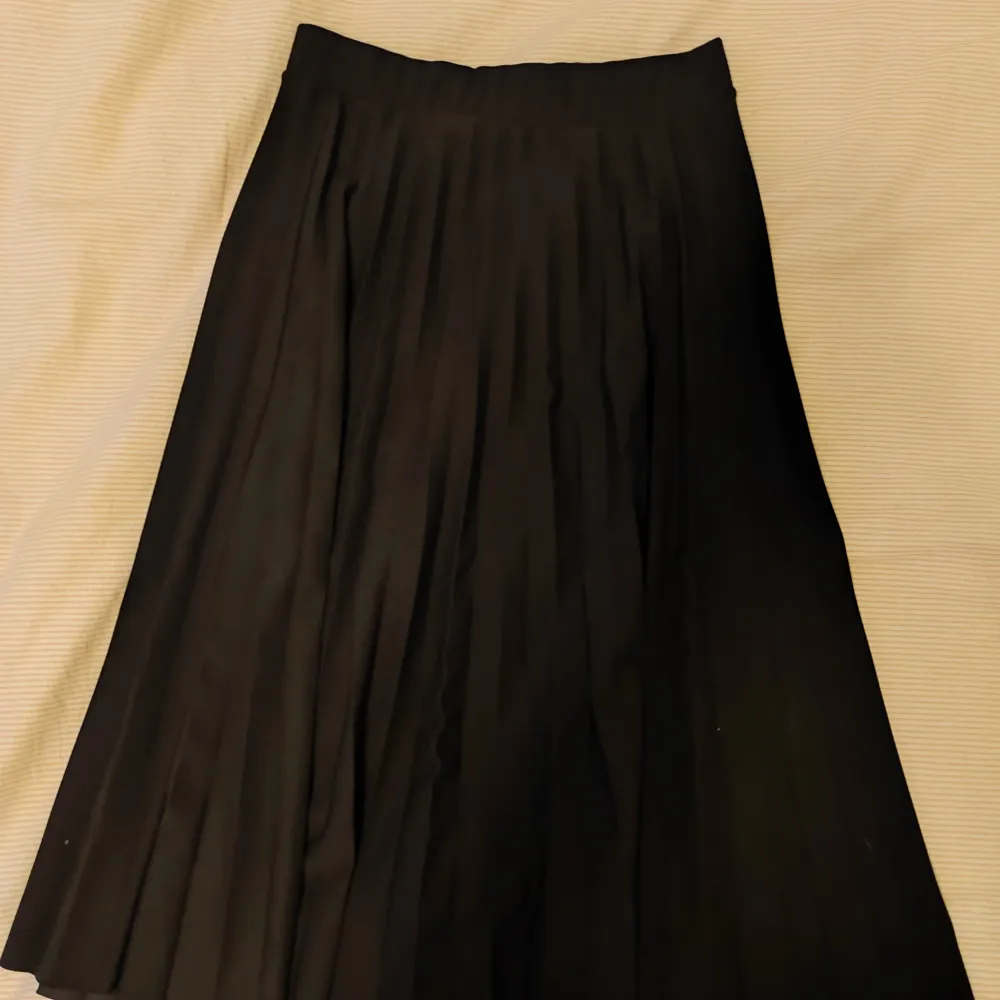 Svart plisserad kjol från Vero Moda i mycket bra skick 🌟 Den går en bit under knäna på mig som är 169 cm 🌸 Köparen står för frakten. Kjolar.