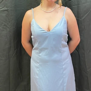 Balklänning  - Bra skick, använd en gång. Den är mer blå i verkligheten, och är skrynkligare på bilden. Den har fint knyte i bak som ger lite backless vibe. Stl L