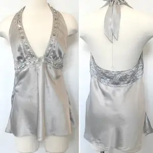 Vintage 00s Y2K unik Victoria’s Secret silver/lila halterneck rhinestone top.  Storlek S, material 100 % silke. Otroligt fin topp i nyskick som jag inte fått användning för, så därför säljer säljer jag den. Kan mötas upp i Stockholm eller skicka. 