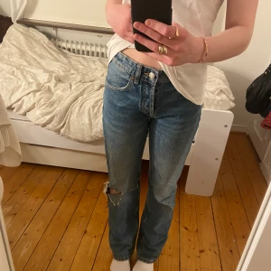 Snygga jeans från Zara! - Snygga straight jeans från Zara med ett hål på ena knät! Byxorna är midrise och går på mig upp till lite under naveln! Nypris är 359 kr, pris går att diskuteras!