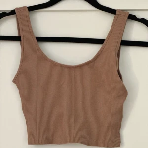 Brun/beige top - En topp från Gina Tricot i storlek XS🦦 Toppen är knappt använd och är alltså i väldigt bra skick! Perfekt att ha nu inför sommaren när det blir varmt! 