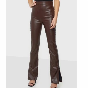 Bruna Skinnbyxor bootcut med slits - Snygga bootcut fake skinnbyxor från NLY trend med slits på sidan. Väldigt bekväma. Storlek M. Säljer då dom inte är min stil längre.