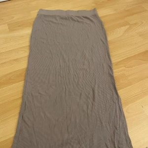 Kjol - Säljer en mörk beige kjol med en sluta på sidan.