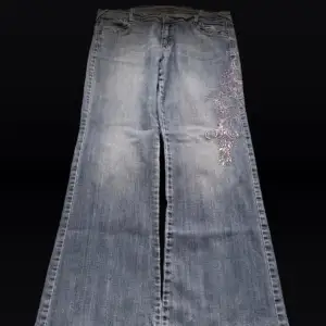Low waist bootcut jeans med broderade blommor på sidan av benet! Super fina men inte min stil längre 💓Längd 108 cm ytterben, midja 47 cm  rakt över och benöppning 27 cm (längst ner på byxan) 💓