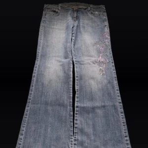 Low waist bootcut jeans  - Low waist bootcut jeans med broderade blommor på sidan av benet! Super fina men inte min stil längre 💓Längd 108 cm ytterben, midja 47 cm  rakt över och benöppning 27 cm (längst ner på byxan) 💓