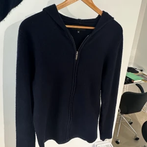  Stickad full zip hoddie - Säljer nu denna snygga mörkblåa ull zip som endast är tetsad (10/10). Retail ligger på 1700kr ungefär. Storlek M. Bara att höra av er vid frågor. Mvh Liam!