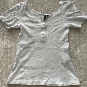 Pieces T-shirt  - T-shirt från Pieces. Har aldrig använt denna t-shirt då den inte sitter så bra på mig men jag glömde att lämna tillbaka den