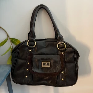 Vintage handväska - Super snygg vintage handväska med guld detaljer💛nästintill aldrig andvänd. Bredd: ca 30 cm, Djup:  12 cm, Höjd: 21 cm💗 Tyvärr så har en dragkedja gått av (se i bild 3 ) men annars perfekt skick💗 